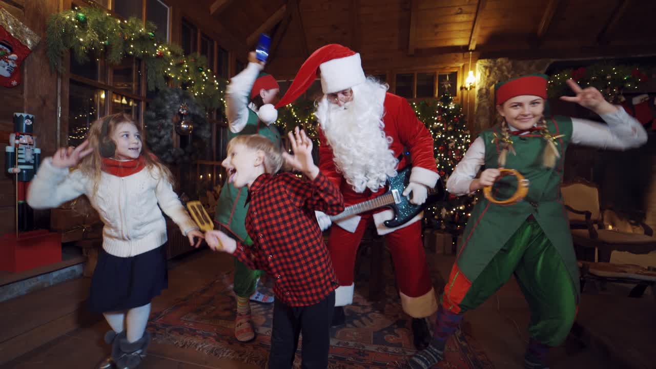 Children and Santa Claus. Santa Claus dancing with children and elves in residence