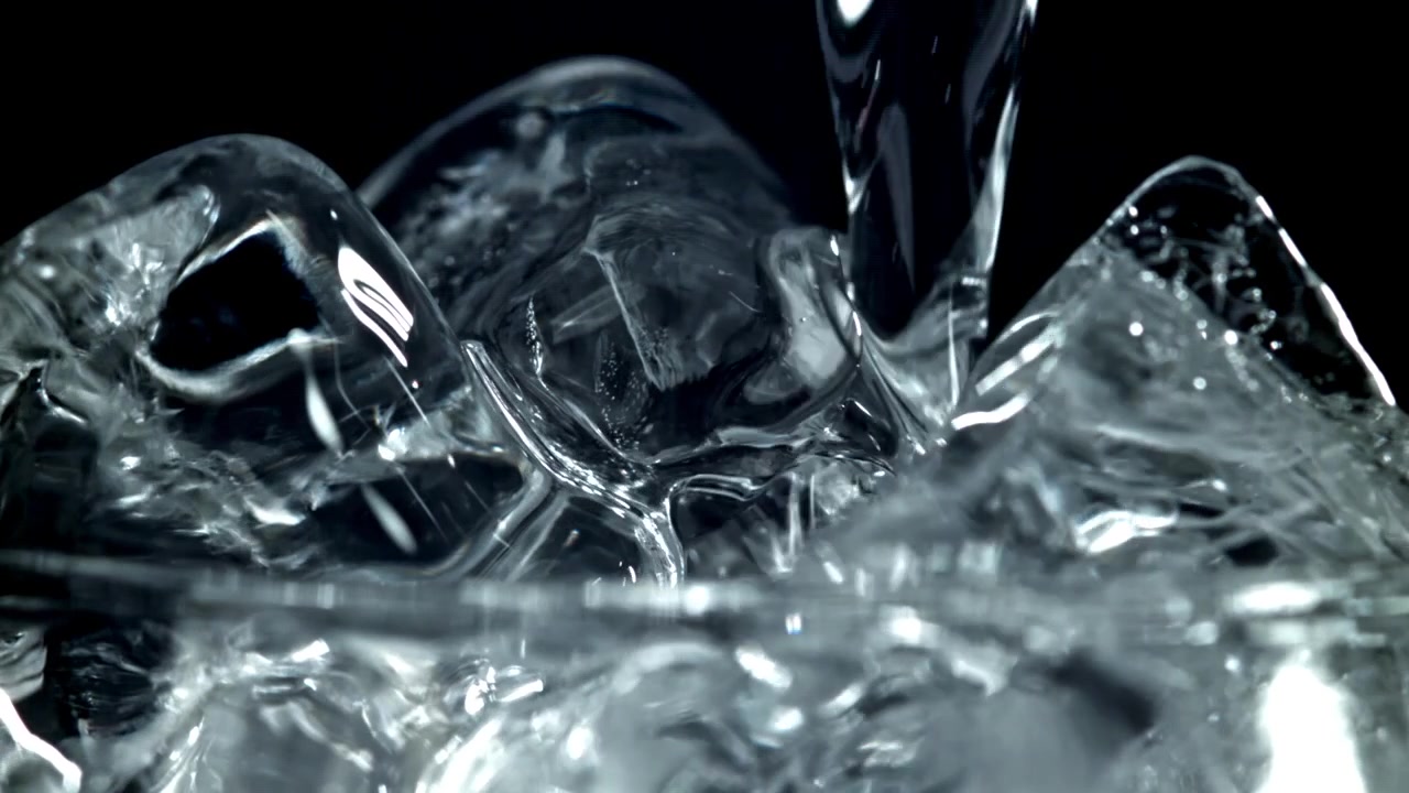 Acqua rinfrescante che si versa su cubetti di ghiaccio al rallentatore