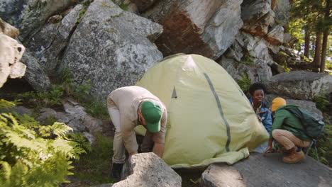 cheerful multiethnic family setting up campsite