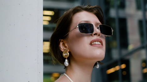 close-up view of elegant woman in sunglases and earrings