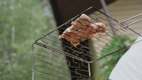 Bottom-view-of-raw-meat-steak-on-the-campfire-grill