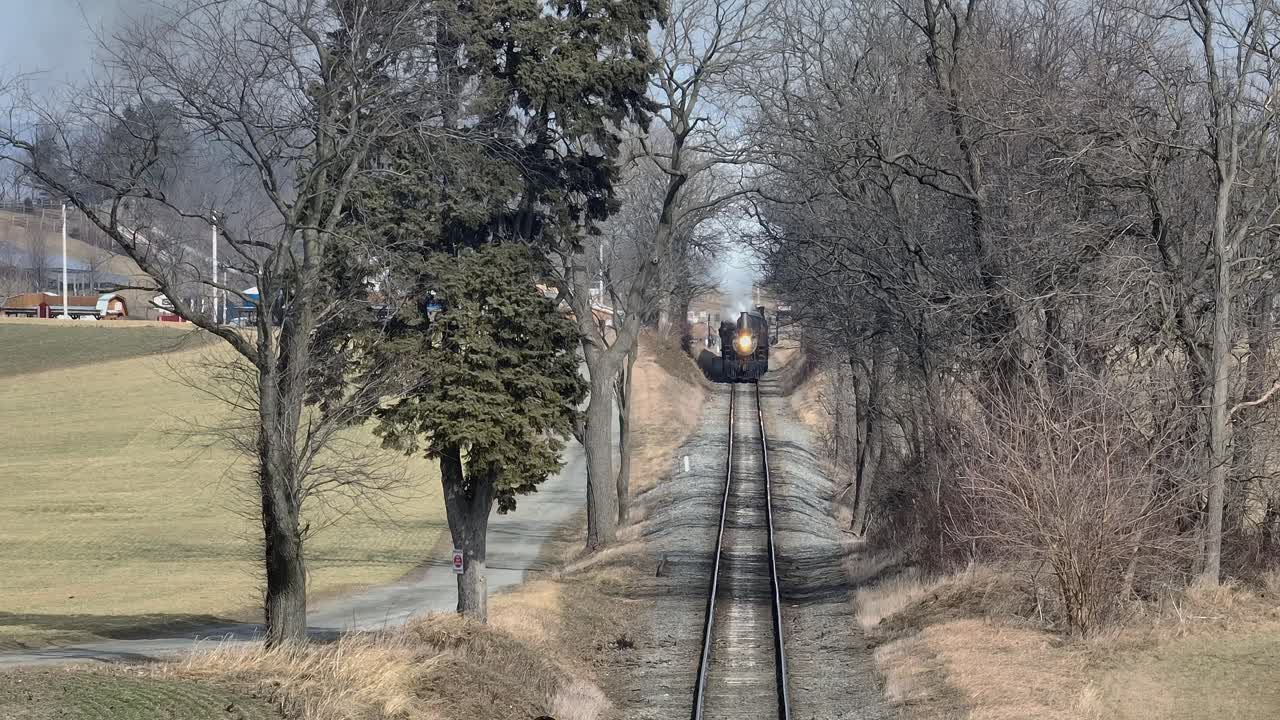 A steam locomotive travels through a serene winter landscape surrounded by bare trees and countryside smooth motion cinematic quality stunning visuals