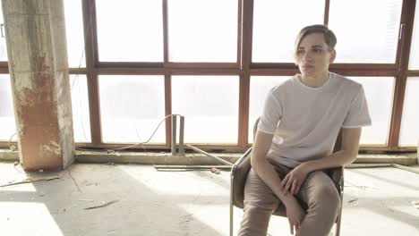 Young-trendy-man-sitting-on-chair-in-hall