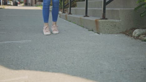 Langbeinige-Frau-In-Skinny-Blue-Jeans,-Die-Mit-Dem-Zehenklopfen-Steht---Low-Level-Aufnahme