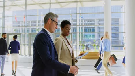 Multi-ethnics-business-people-discussing-over-digital-tablet-in-the-office-lobby-4k