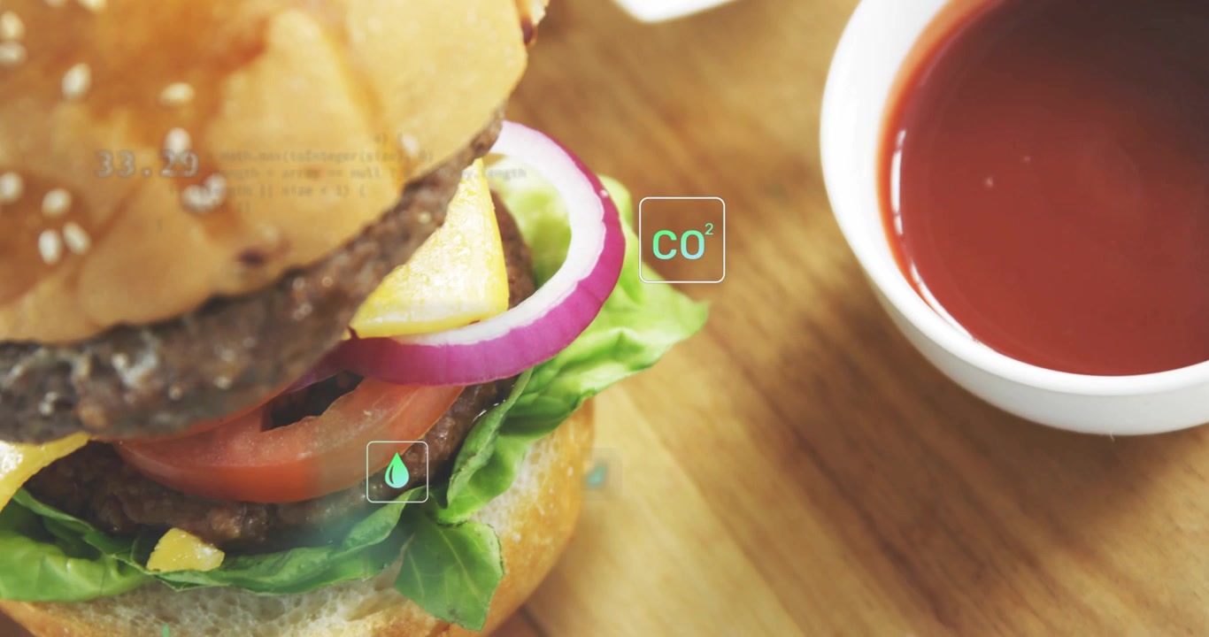 HUD icons appearing over fries, camera panning left to reveal burger, visualizing CO2 metrics