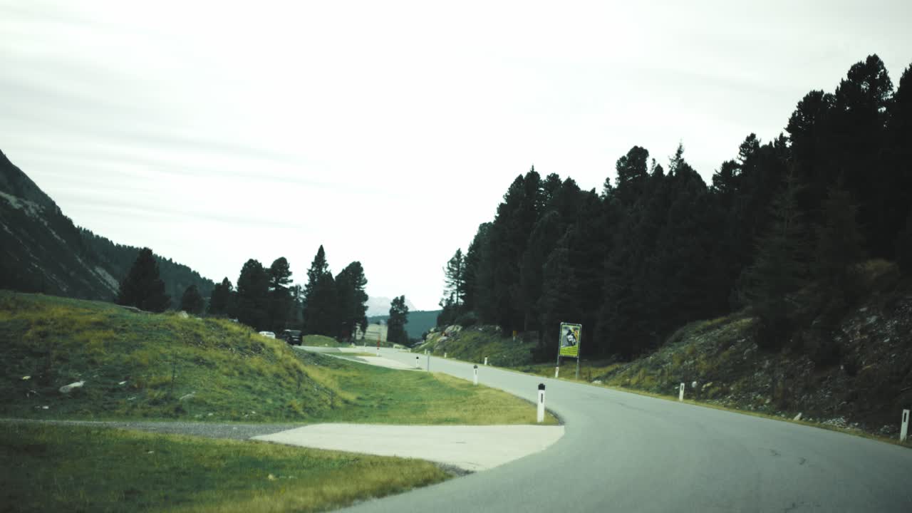 흐린 날 잔디밭이 있는 산길의 비오는 숲을 운전하다