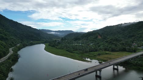 Vista-Aérea-De-Drones-De-La-Impresionante-Carretera-Sobre-El-Río-En-La-Ciudad-De-Bato,-Islas-Catanduanes