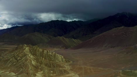 aerial scene of the mountains of leh ladakh where the mountains are surrounded by clouds in rainy weather and dark cumulonimbus clouds are seen filled with water