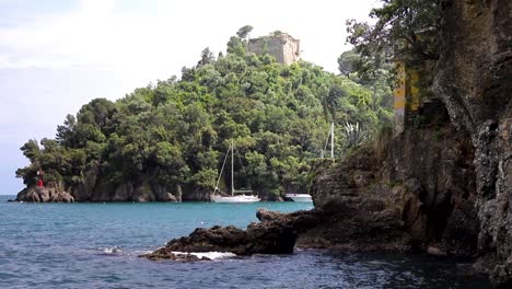 portofino italy coastline with sailboats anchored and castle ruins