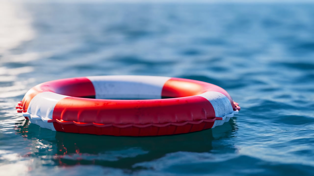 Red Lifebuoy Floating On Water, Sunlight Glinting On Gentle Waves, Closeup Of Red And White Ring Drifting