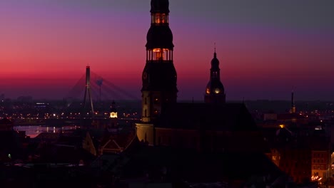 riga’s skyline glows in deep purple, red hues after sunset over the city, latvia