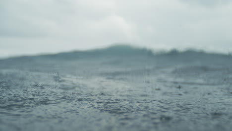 in water slow motion capture of rain hitting ocean surface with ripples