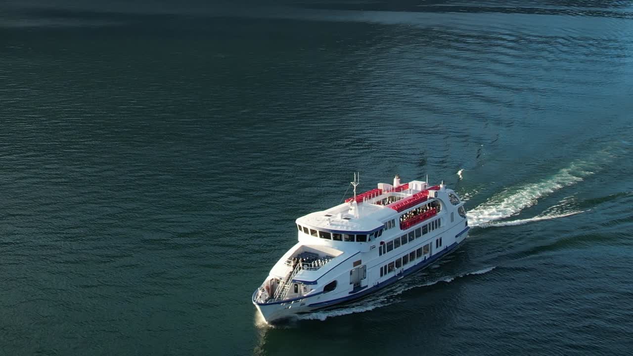 Scenic aerial view of a ferry cruising in the clear waters of the Alps