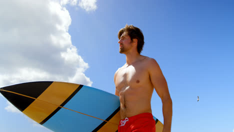 Bottom-view-of-surfer-man-holding-his-surfboard-4k