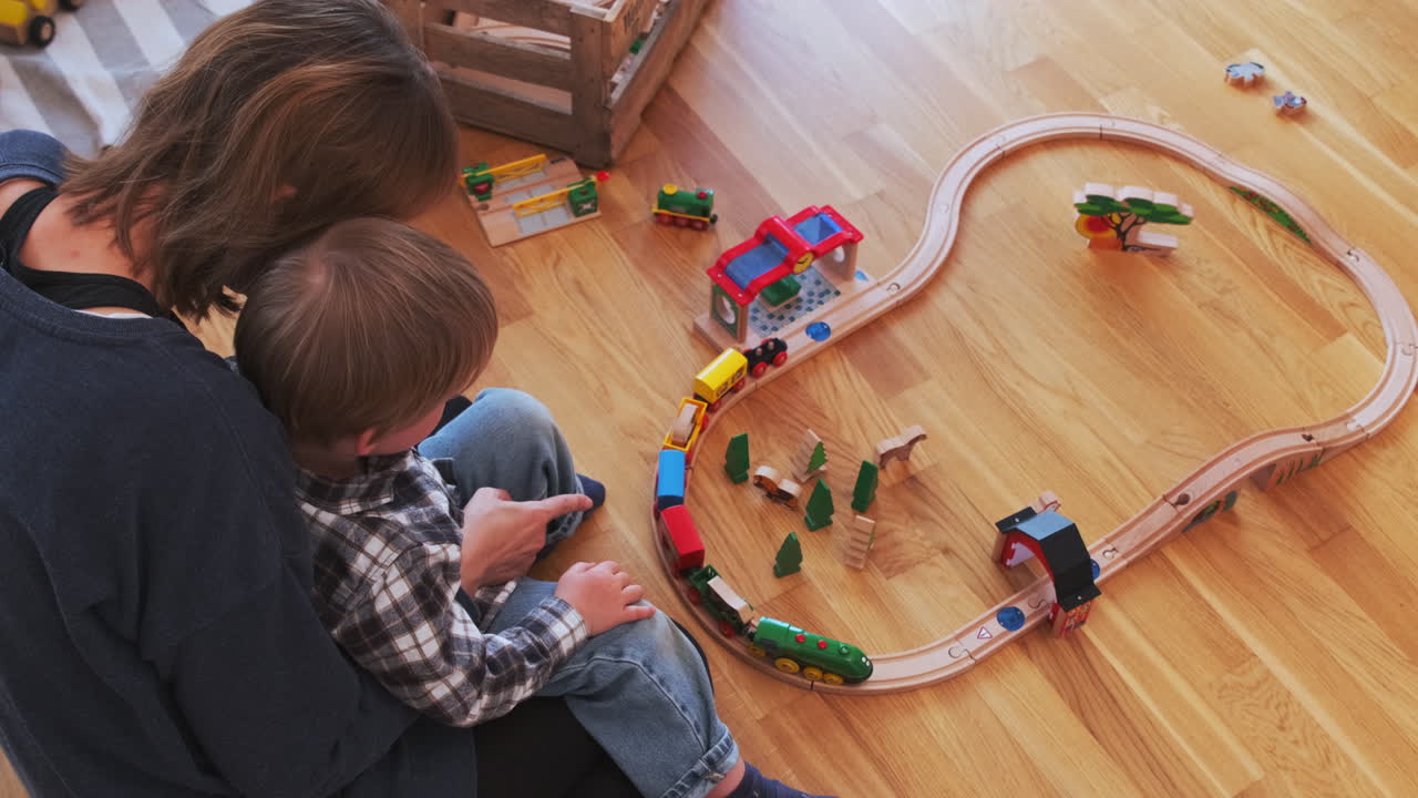 Mother and Toddler Playing with Wooden Train Set