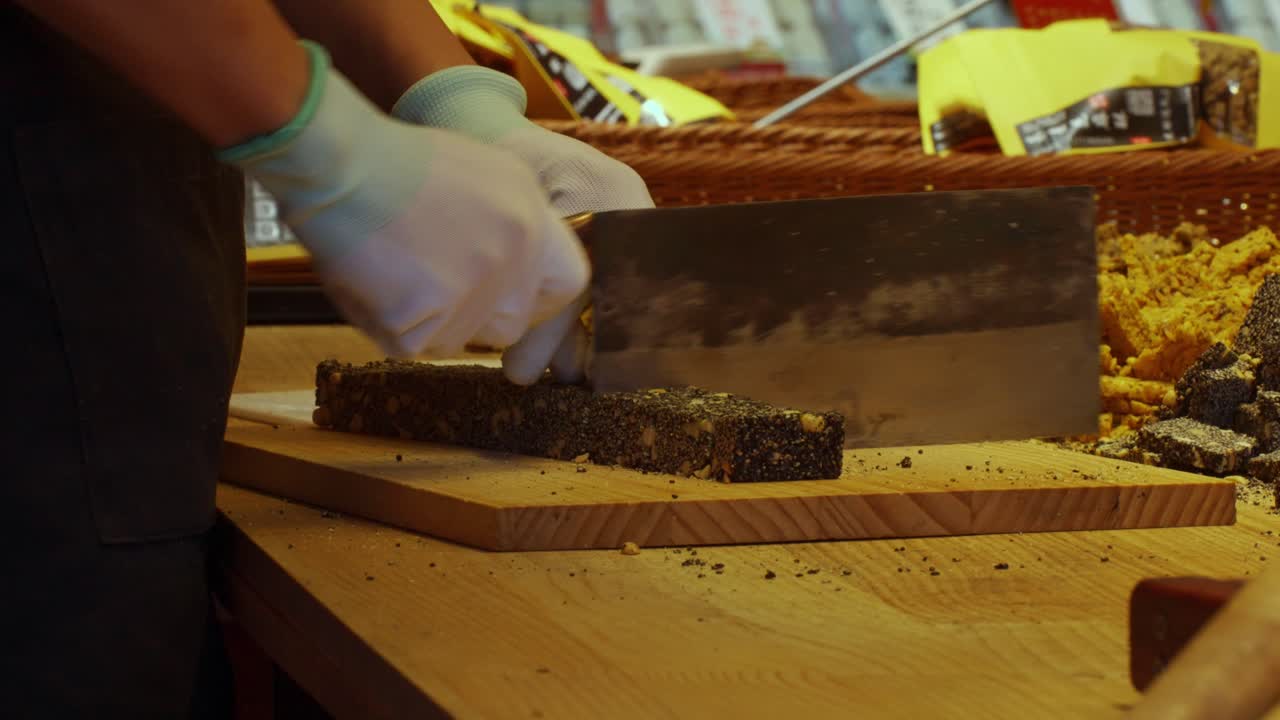 Close Up of Vendor Cutting Traditional Chinese Sesame Seed Candy