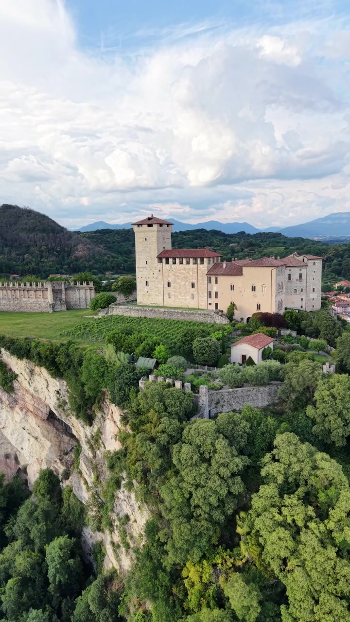La Rocca di Angera, conosciuta anche come Castello Borromeo ad Angera, Lombardia, Italia, con la sua fortezza storica e il paesaggio circostante - ripresa verticale con drone