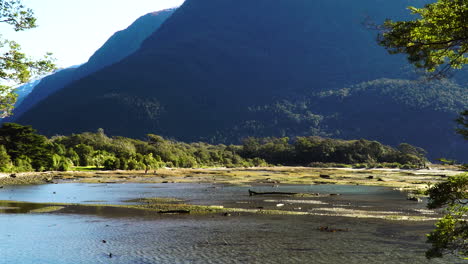 La-Silueta-De-La-Gente-Disfruta-De-Un-Río-Poco-Profundo-En-Milford-Sound,-Aleja-La-Vista