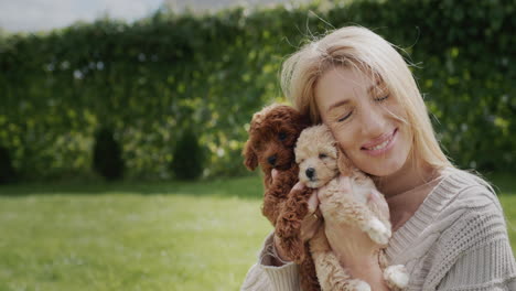 portrait of a young woman, presses cute fluffy puppies to her cheek