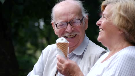 happy elderly couple enjoying ice cream together