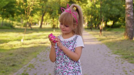 Child-girl-playing,-spinning-push-pop-it-bubble-fidget-toy,-stress-anxiety-relief,-hand-spinner-game