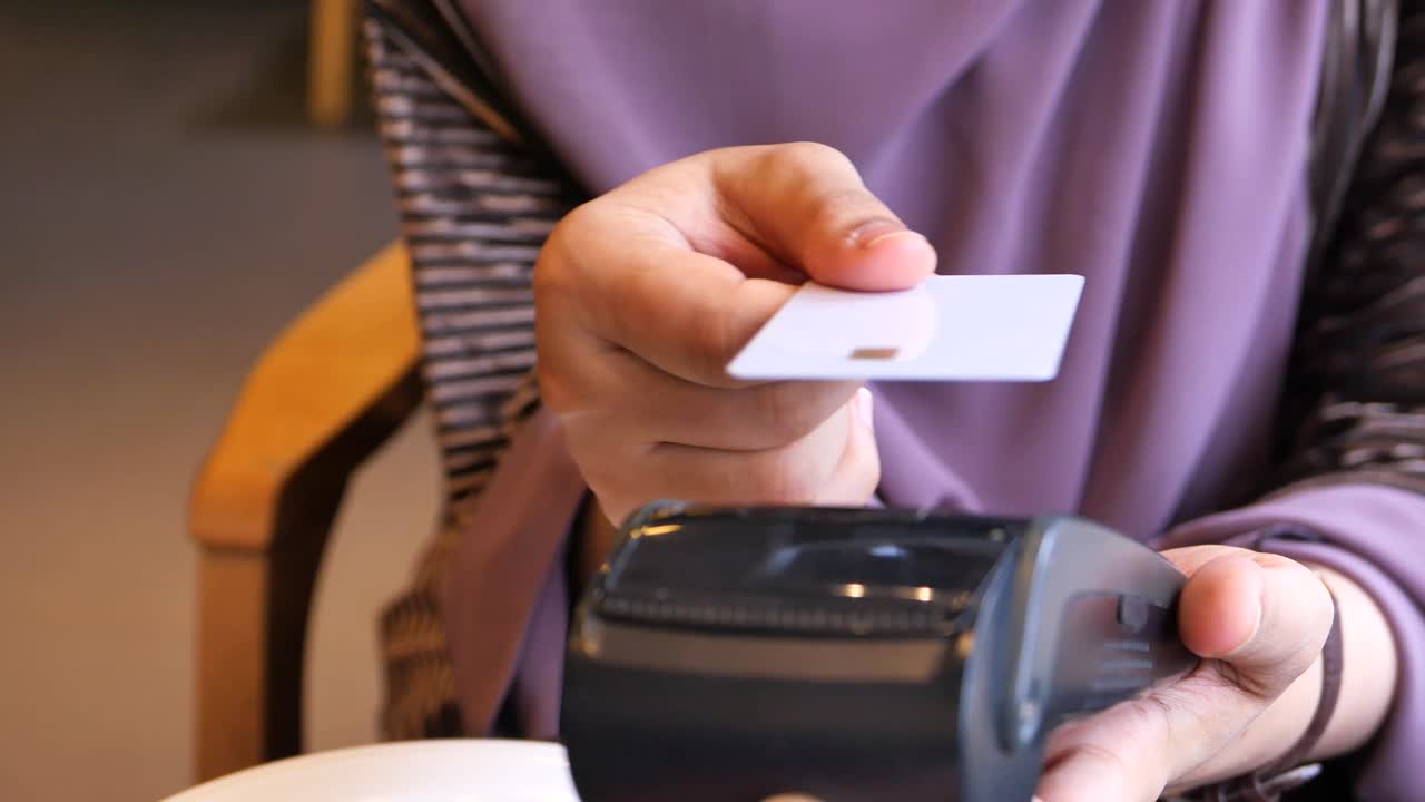 Mulher pagando com cartão de crédito em um café