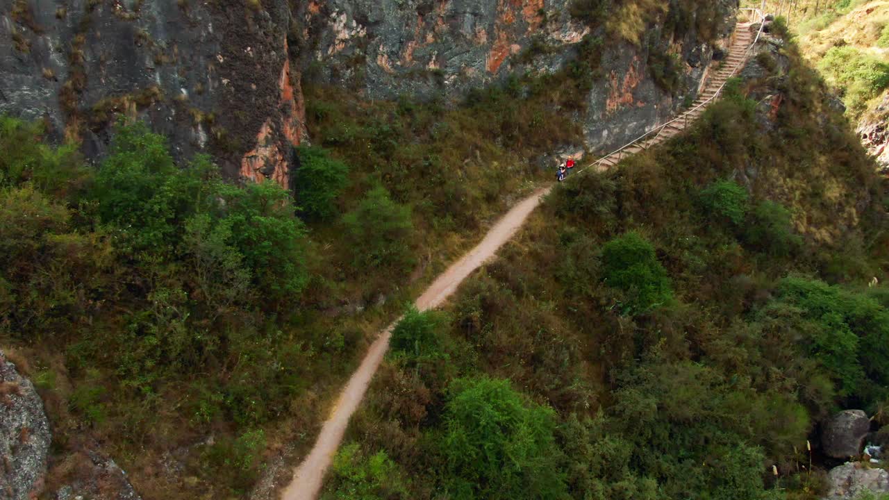 Panoramic drone view of hikers on Qhapaq Ñan road network from Inkilltambo to K'allachaka ruins, Cusco, Peru