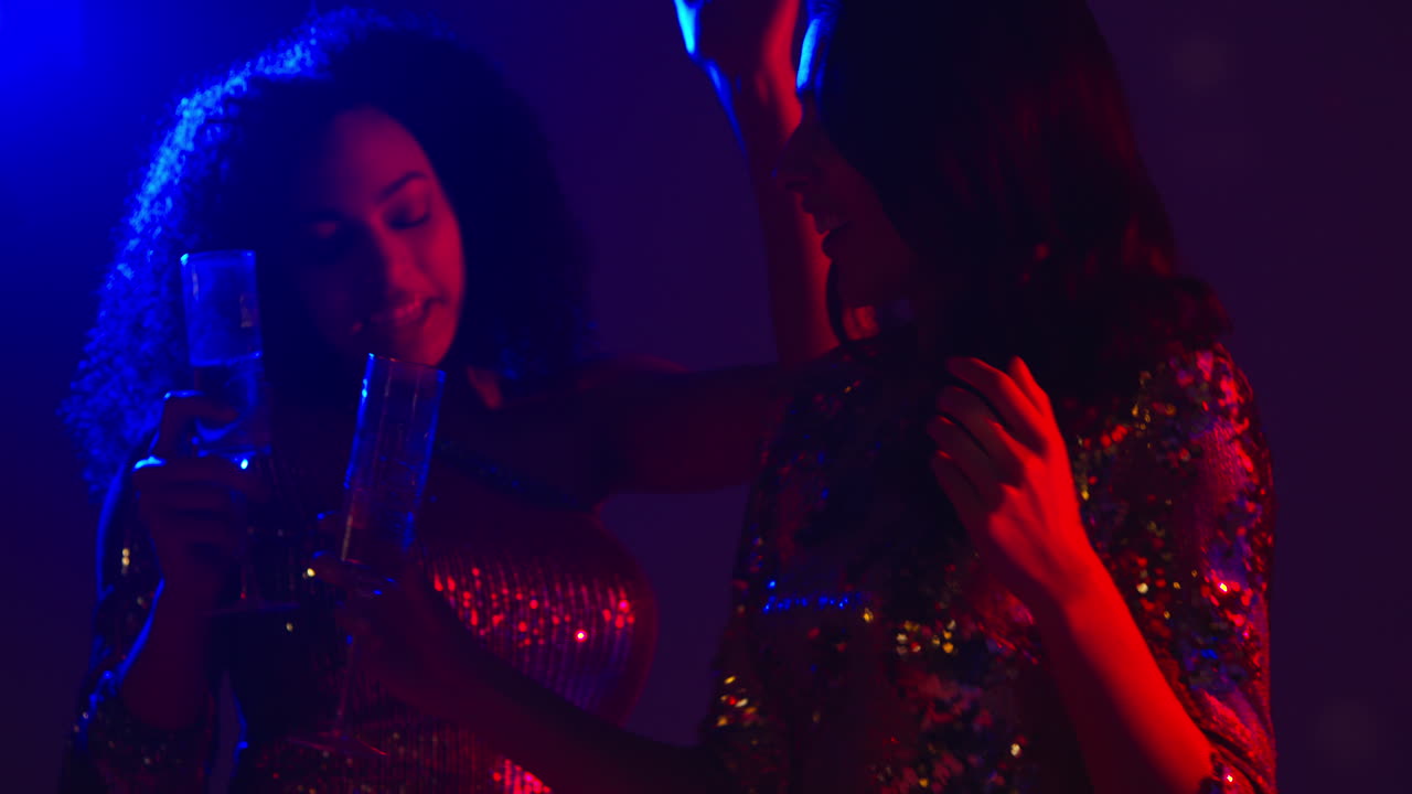 cerca de dos mujeres en un bar de club nocturno o discoteca bailando y bebiendo alcohol 4