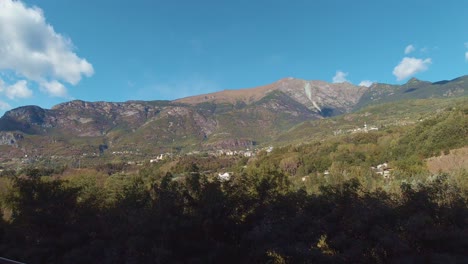 una vista tranquila desde la carretera de eslovenia de valles escénicos con enormes montañas, bosques verdes y ríos verdes que fluyen bajo el cielo azul cristalino con nubes blancas