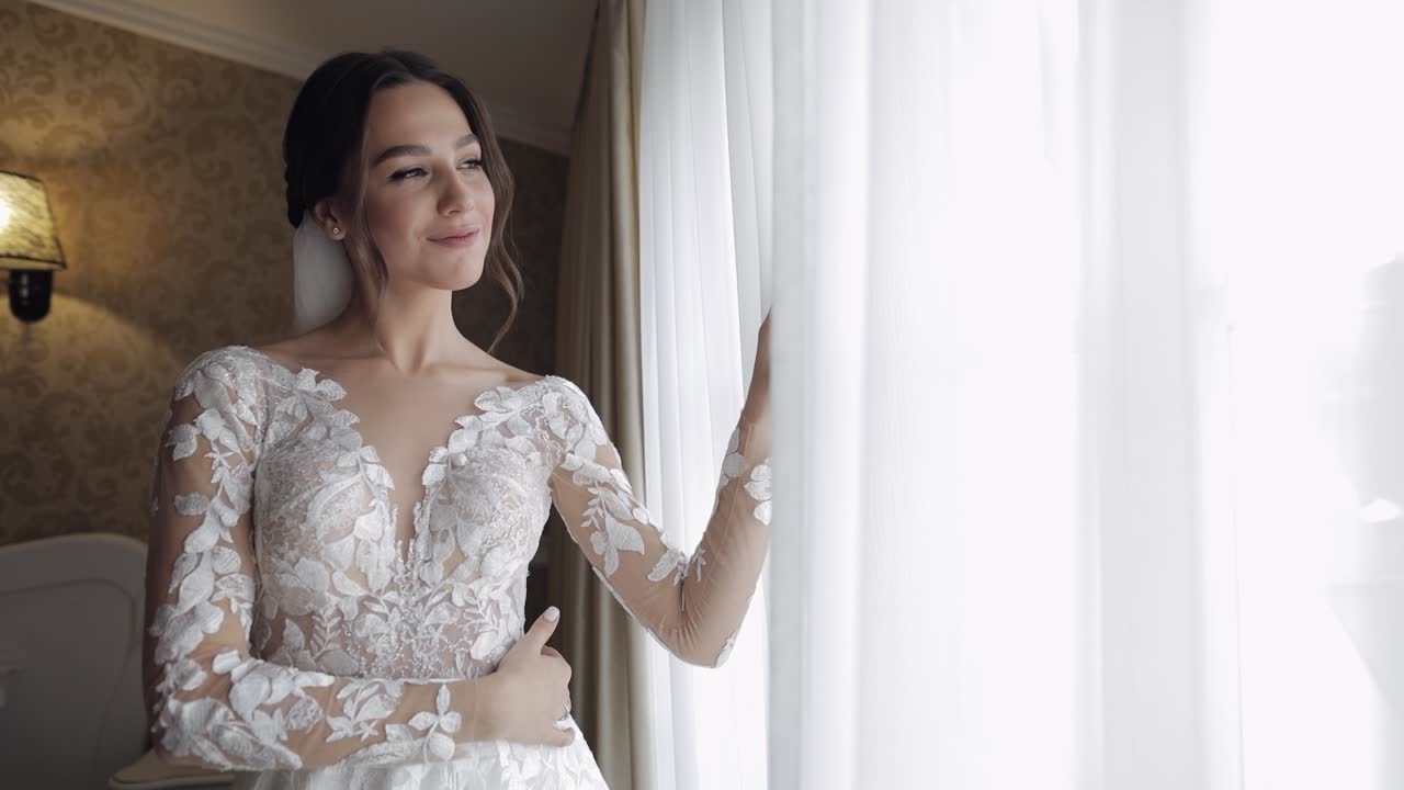 창문 근처의 부도어 드레스를 입은 신부. 결혼식 아침 준비. 야간 드레스와 베일을 입은 여성