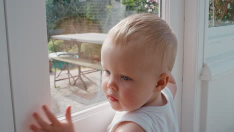 baby looking out window curious toddler learning to walk exploring home childhood development 4k footage