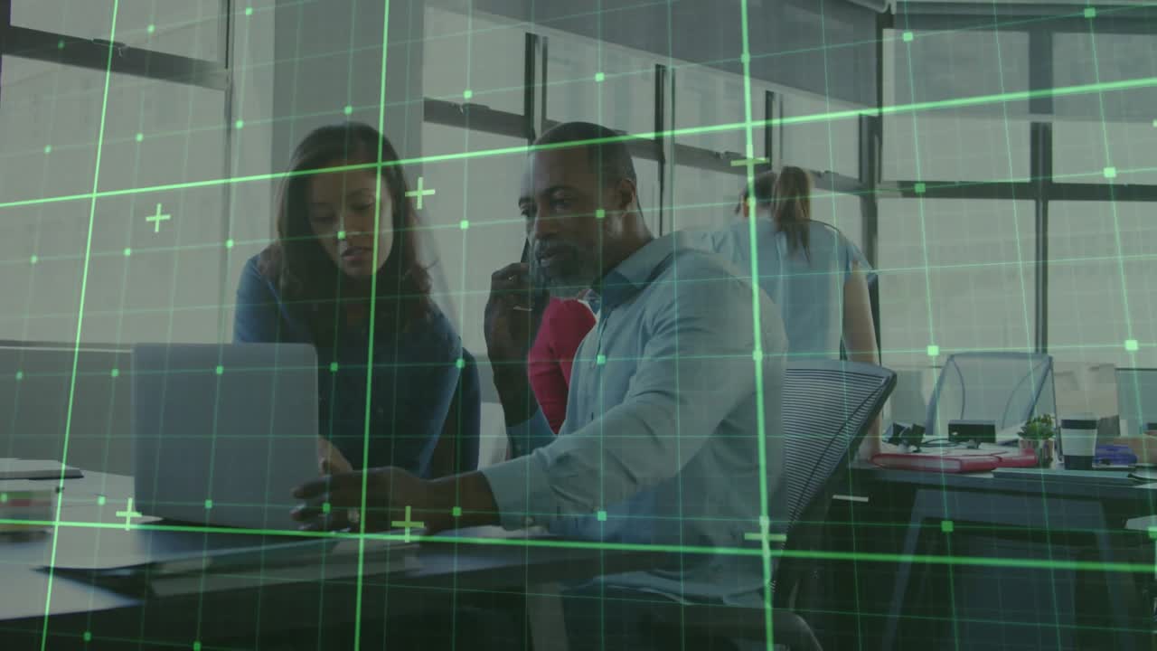 Man taking incoming call while typing with office woman, faint green grid scanning laptop reviewing