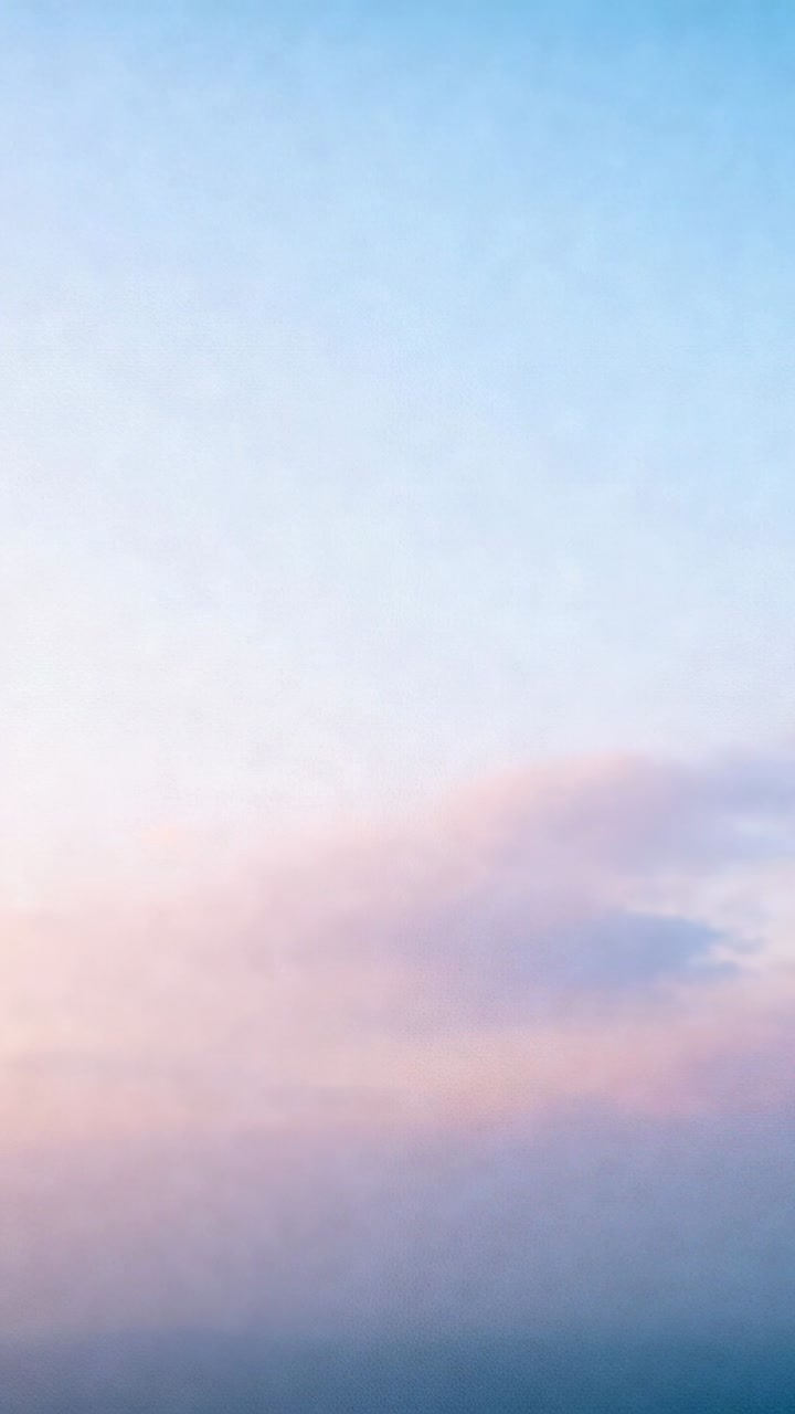 Vertical video: Shifting sunlight deepening sky gradient at sunrise, showing thin cloud bank