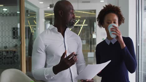 diversos colegas de negocios hombres y mujeres hablando, un hombre sosteniendo documentos en la oficina
