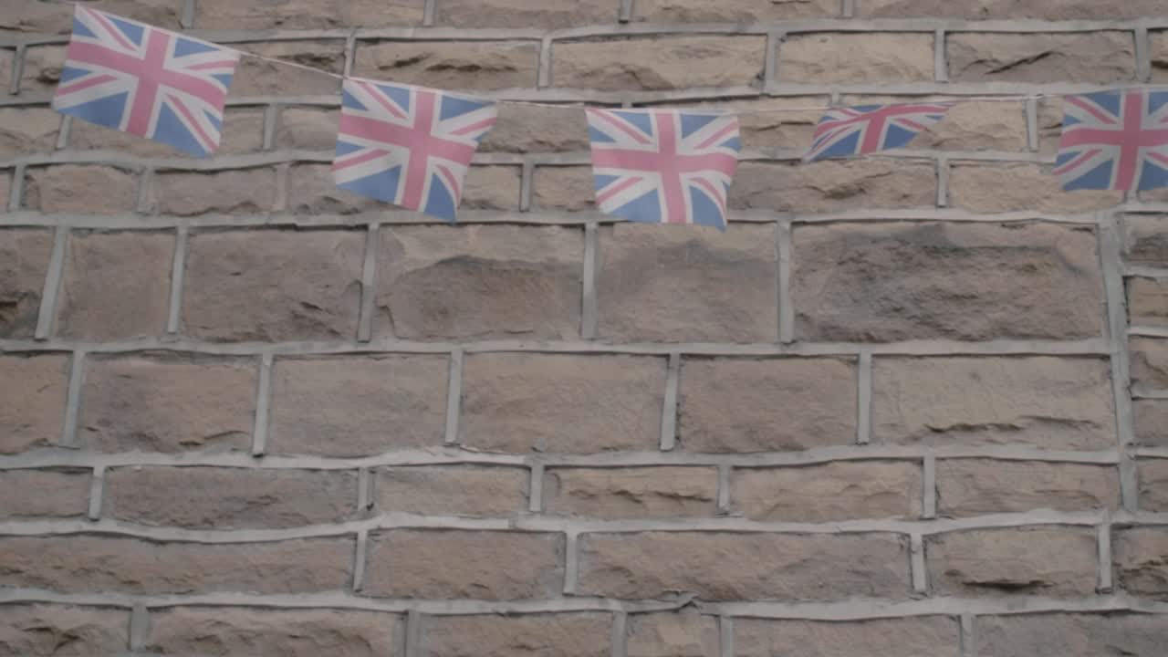 union jack banderines de bandera británica colgando de una pared en la brisa