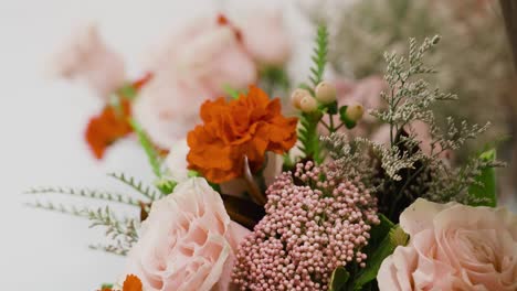 rosas rosadas, claveles rojos y otras adiciones reunidas en un ramo romántico