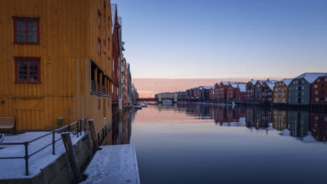 casas coloridas que se reflejan en las aguas del río nidelva en trondheim, noruega al atardecer