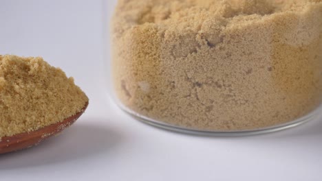 close-up of brown sugar in a spoon and jar