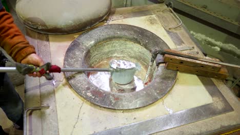 trabajador masculino recogiendo la olla de fundición de moldes de aluminio fundido