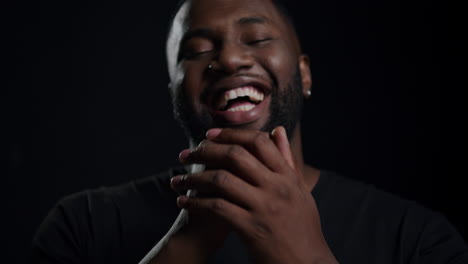 Joyful-afro-guy-laughing-in-studio.-African-american-man-making-gestures-indoors