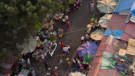 explore the vibrant atmosphere of a market in phnom penh as the sun sets. vendors display colorful goods while locals gather, creating a lively community scene filled with energy and culture.