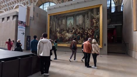 people observing a large painting in paris museum