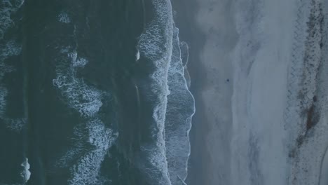 Top-down-shot-of-the-waves-crashing-along-the-shore