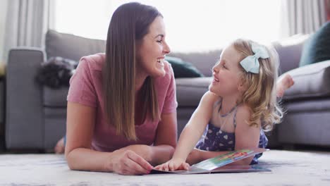 caucasian mother and daughter having fun reading book