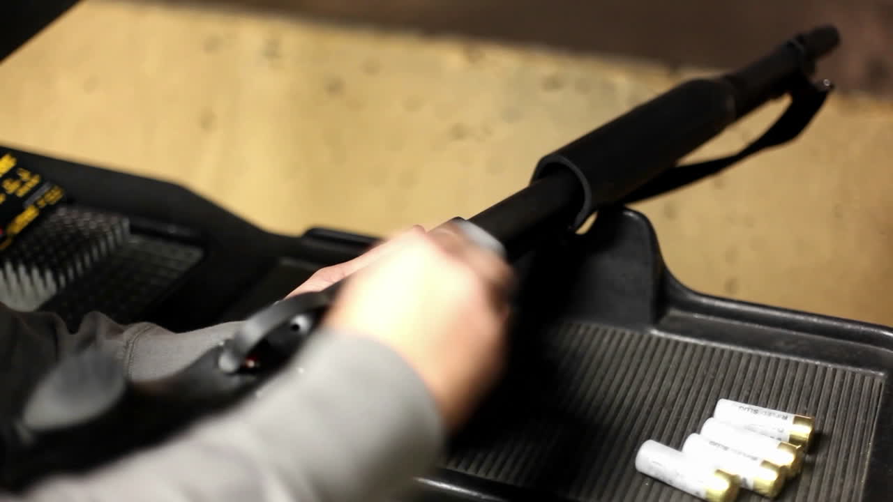 한 남자가 실내 사격장에서 소총을 장전합니다.