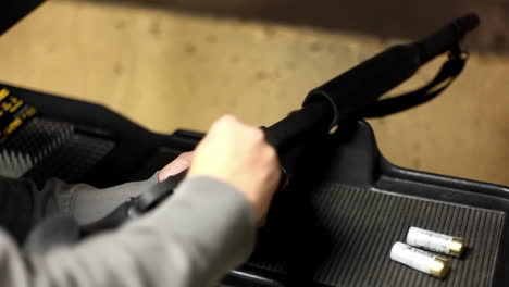 a man loads a rifle at an indoor shooting range