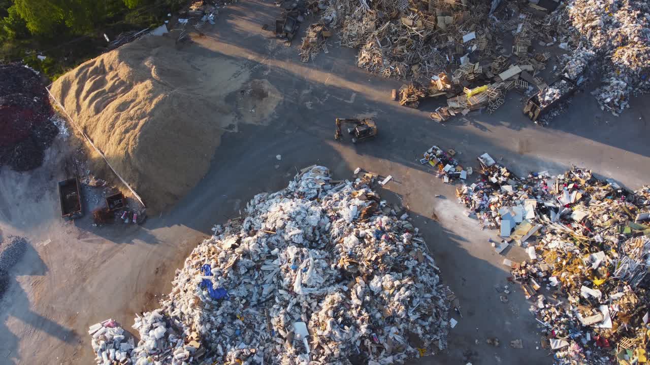 excavadora moviéndose hacia adelante en un vertedero en una noche soleada