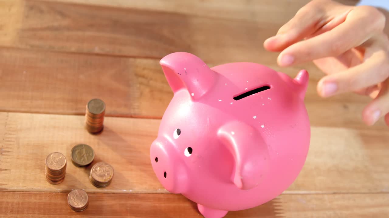 Woman putting coin in piggy bank