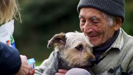 an elderly man sits outdoors, smiling as he interacts with a loving dog. the sun gently rises behind them, creating a peaceful atmosphere filled with warmth and companionship.